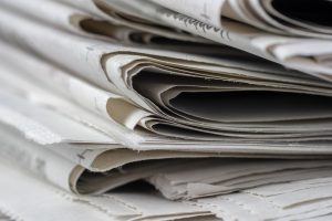 closeup-shot-newspapers-stacked-top-each-other1